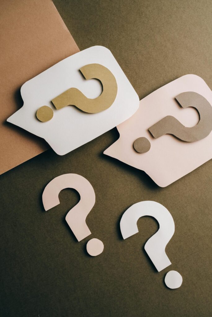 pexels-photo-5428835-5428835 Artistic paper cutouts of question marks creating a conceptual design on a brown surface.